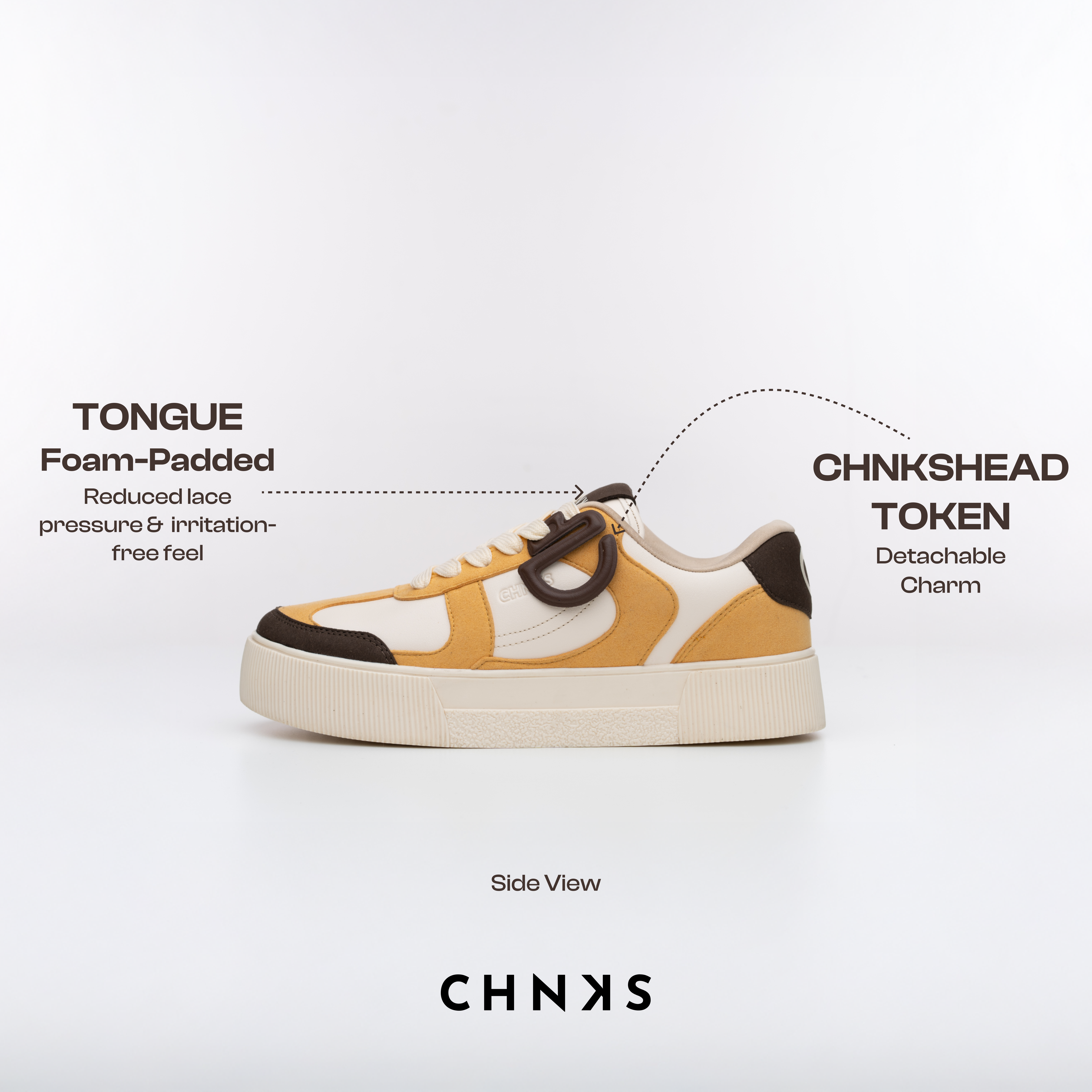 Side view of CHNKS low‑top sneaker in cream, mustard, and brown with a foam‑padded tongue and detachable CHNKSHEAD token charm; homegrown sneaker brand for men and women