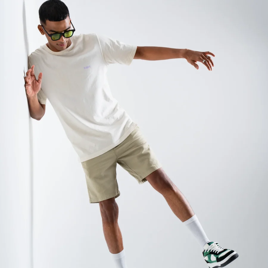 Model wearing Matrix CHNKS sneakers with white t-shirt and beige shorts – men’s green streetwear sneakers